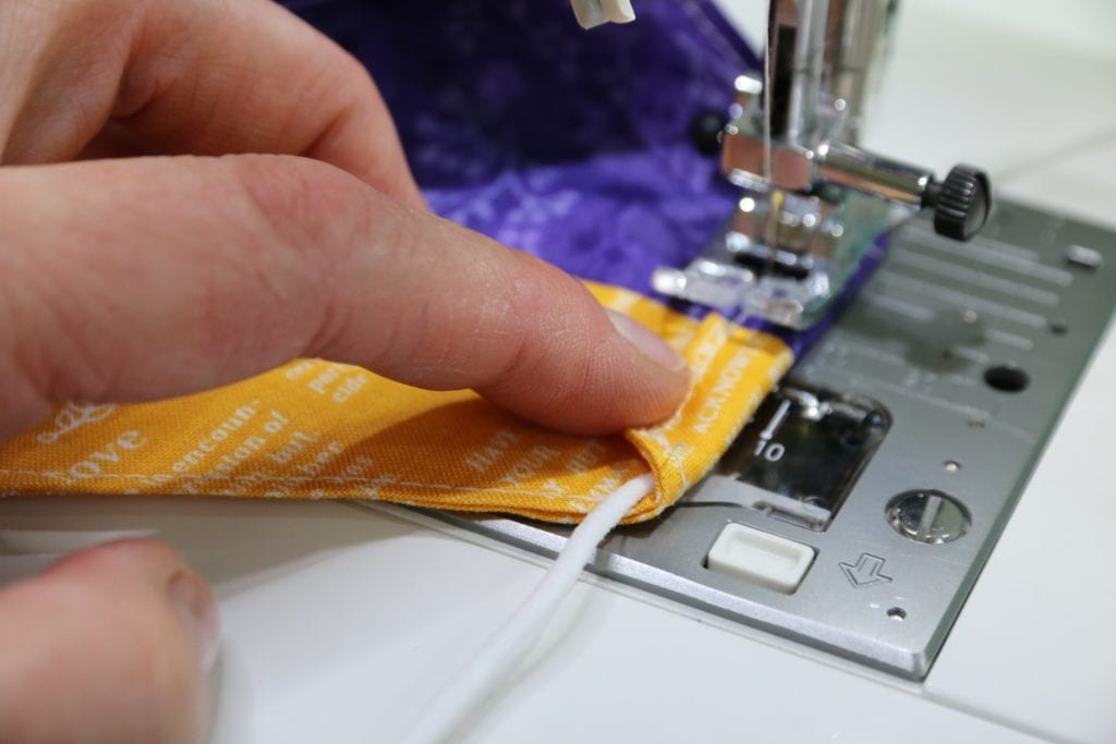 Seitliche Kante über Gummiband falten und fest steppen