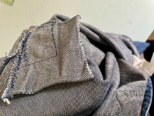 Jeans zwischen den Beinen mit der Nähmaschine reparieren