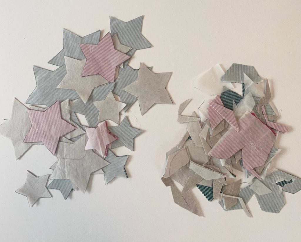 Geschenkverpackung nähen: ausgeschnittene Sterne mit Stoffschnipseln